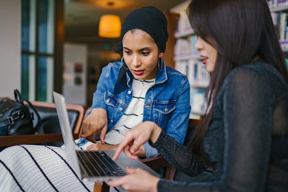 women sitting with a laptop